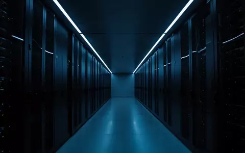 Minimalistische, blau beleuchtete Architektur eines modernen Technikraums mit klaren Linien und tiefen Schatten. - Foto: über boerse-global.de