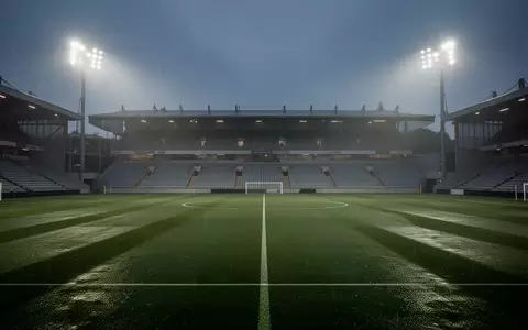 Ein leerer, professioneller Fußballplatz bei Dämmerung unter Flutlicht, der eine Atmosphäre von Konzentration und mentaler Stärke vermittelt. - Foto: über boerse-global.de