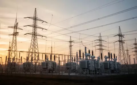 Moderne Hochspannungs-Strommasten und Transformatoren in einer Industrieanlage bei Sonnenuntergang. - Foto: über boerse-global.de