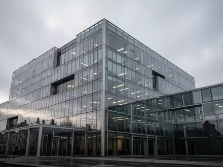 Ein modernes Bürogebäude aus Glas und Stahl in Brüssel unter einem bewölkten Himmel. - Foto: über boerse-global.de