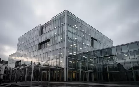 Ein modernes Bürogebäude aus Glas und Stahl in Brüssel unter einem bewölkten Himmel. - Foto: über boerse-global.de