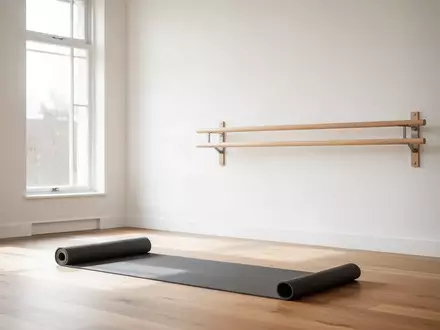 Ein minimalistischer Fitnessraum mit Holzboden, einer ausgerollten Yogamatte und einer stabilen Wandhalterung für das Training. - Foto: über boerse-global.de