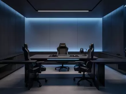 Ein modern eingerichtetes Gaming-Zimmer mit minimalistischem Schreibtisch und stimmungsvoller blauer Beleuchtung. - Foto: über boerse-global.de