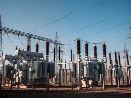 Moderne elektrische Umspannstation mit Hochspannungsmasten unter blauem Himmel. - Foto: über boerse-global.de