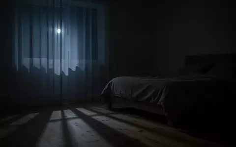 Ein minimalistisches Schlafzimmer in der Nacht, in dem schwaches Mondlicht durch einen Vorhang fällt und sanfte Schatten wirft. - Foto: über boerse-global.de