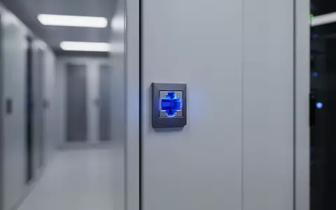 Ein blau leuchtender Netzwerkanschluss an einer Wand in einem modernen Serverraum. - Foto: über boerse-global.de