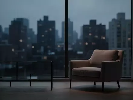 Ein leerer Sessel in einem minimalistisch eingerichteten Raum bei Dämmerung mit Blick auf eine nächtliche Stadtlandschaft. - Foto: über boerse-global.de