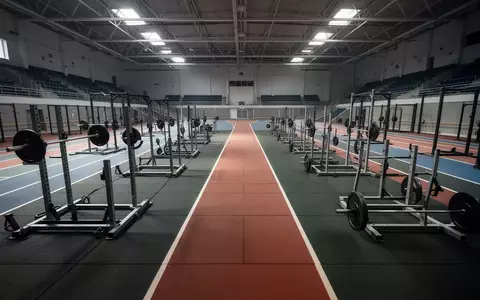 Leere, professionelle Sportarena mit Gummiboden und Trainingsgeräten in einer Wettkampfhalle. - Foto: über boerse-global.de