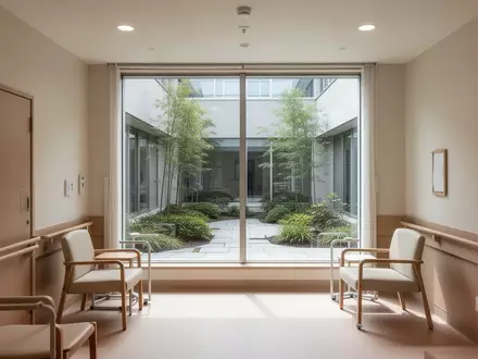 Ein heller, leerer Raum in einer Pflegeeinrichtung mit Blick in einen ruhigen Garten bei Tageslicht. - Foto: über boerse-global.de