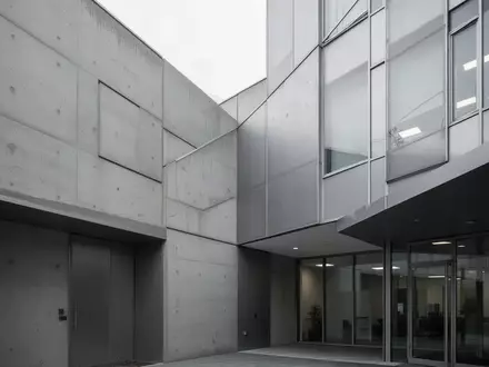 Ein modernes Bürogebäude mit schlichter Architektur an einem bewölkten Tag. - Foto: über boerse-global.de