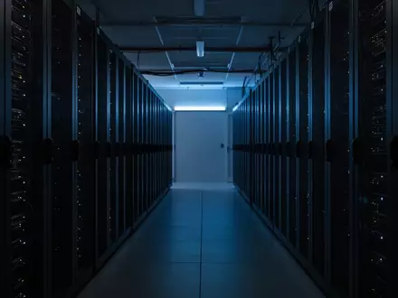 Dunkler Serverraum mit unbeleuchteten Server-Racks in einem industriellen Rechenzentrum. - Foto: über boerse-global.de