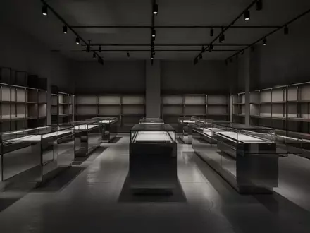 Ein leerer, minimalistischer Verkaufsraum mit Glasvitrinen und Regalen in einer gedimmten, atmosphärischen Beleuchtung. - Foto: über boerse-global.de