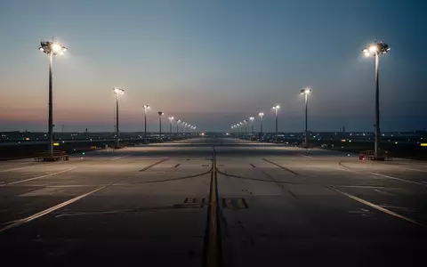 Weitläufiges, leeres Vorfeld eines Flughafens bei Dämmerung mit Bodenmarkierungen und Flutlichtbeleuchtung. - Foto: über boerse-global.de