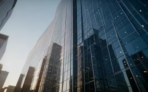 Moderne Glasfassade eines Bürogebäudes bei klarem Himmel als Symbol für Finanzmärkte und Aktienwachstum. - Foto: über boerse-global.de