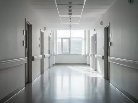 Ein heller, leerer Krankenhausflur mit natürlichem Tageslicht und minimalistischer Architektur. - Foto: über boerse-global.de