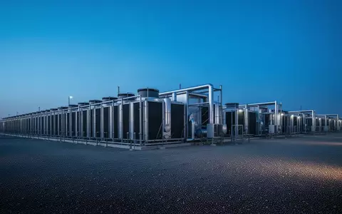 Eine weitläufige industrielle Kühlanlage für Rechenzentren bei Dämmerung, die die enorme Infrastruktur und den Energiebedarf symbolisiert. - Foto: über boerse-global.de
