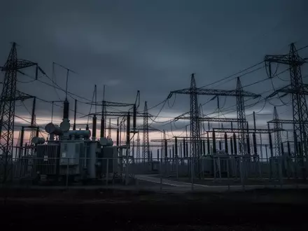 Ein weitläufiges Umspannwerk mit Hochspannungsmasten und Transformatoren in der Dämmerung. - Foto: über boerse-global.de
