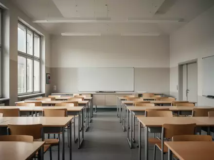 Ein leerer, modern gestalteter Klassenraum mit hellen Holztischen und großen Fenstern in einem Schulgebäude. - Foto: über boerse-global.de