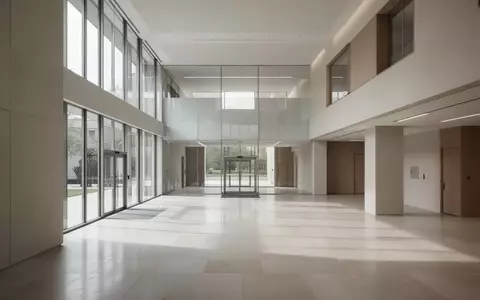 Ein minimalistisches, helles Interieur eines modernen Verwaltungsgebäudes mit klaren architektonischen Linien und Tageslicht. - Foto: über boerse-global.de