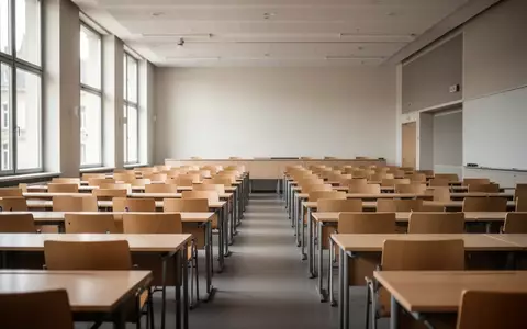 Ein leerer, moderner Hörsaal an einer europäischen Universität mit Holztischen und Stühlen in einer minimalistischen Architektur. - Foto: über boerse-global.de