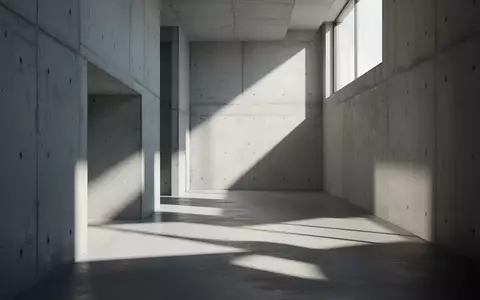 Minimalistische Architektur mit geometrischen Schattenwürfen in einem leeren, lichtdurchfluteten Flur. - Foto: über boerse-global.de