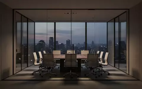 Ein leerer, modern gestalteter Konferenzraum in einem Bürogebäude bei Dämmerung mit Blick auf die Lichter der Stadt. - Foto: über boerse-global.de