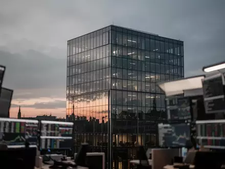 Moderne Glasfassade eines Bürogebäudes in Frankfurt vor einem dämmrigen Himmel, symbolisch für die unklare Marktlage. - Foto: über boerse-global.de