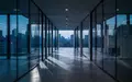 Ein minimalistischer, leerer Büroflur in einem modernen Gebäude bei Dämmerung mit kühler Beleuchtung. - Foto: über boerse-global.de