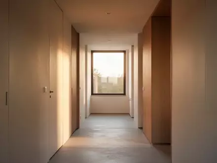 Ein minimalistischer, heller Flur in einem modernen Wohnhaus mit sanftem Tageslichteinfall. - Foto: über boerse-global.de