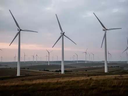 Windkraftanlagen in einer weiten Landschaft bei Dämmerung - Foto: über boerse-global.de