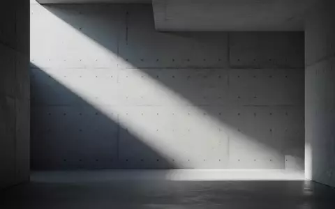 Minimalistische, architektonische Innenansicht mit klaren Licht- und Schattenstrukturen an einer Betonwand. - Foto: über boerse-global.de