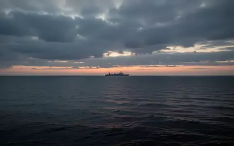 Ruhige Ostsee vor einer Küstenlinie unter bewölktem Himmel bei Dämmerung. - Foto: über boerse-global.de