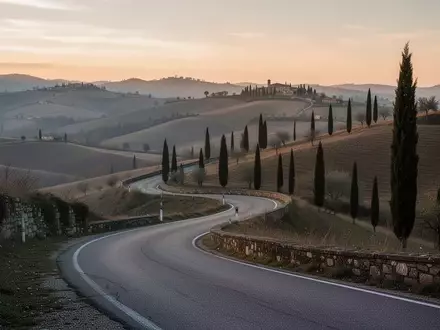 Eine kurvenreiche Landstraße in einer hügeligen italienischen Landschaft bei Tagesanbruch. - Foto: über boerse-global.de