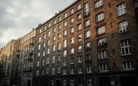 Ein mehrstöckiger Berliner Wohnblock aus Backstein an einem bewölkten Tag. - Foto: über boerse-global.de