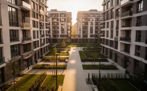 Ein leerer, gepflegter Innenhof zwischen zwei modernen Wohngebäuden bei Sonnenlicht. - Foto: über boerse-global.de