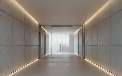 Ein minimalistischer, moderner Flur mit klaren Betonwänden und indirekter Beleuchtung, der eine Atmosphäre von Ordnung und Prüfung vermittelt. - Foto: über boerse-global.de