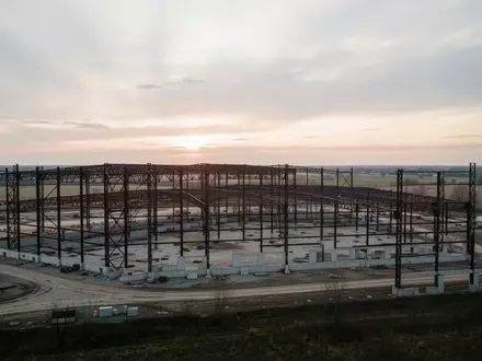 Große, im Bau befindliche Industriehalle in Ohio bei Sonnenaufgang mit Stahlgerüsten vor weitem Horizont. - Foto: über boerse-global.de