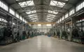 Innenansicht einer großen, modernen Industriehalle mit schweren Produktionsmaschinen und hohen Decken. - Foto: über boerse-global.de