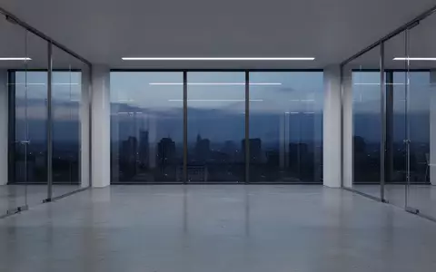 Ein minimalistisch gestalteter, leerer Büroflur in einem modernen Gebäude bei Dämmerung, der Stabilität und Ordnung ausstrahlt. - Foto: über boerse-global.de