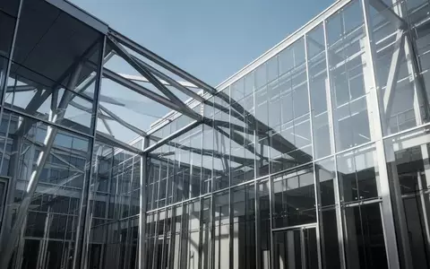 Moderne architektonische Struktur aus Glas und Stahl vor blauem Himmel, die institutionelle Stabilität symbolisiert. - Foto: über boerse-global.de