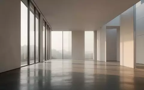Ein minimalistischer, moderner Innenraum mit poliertem Betonboden und hellem Tageslicht, das durch hohe Fenster fällt. - Foto: über boerse-global.de