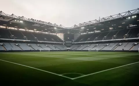 Ein leeres Fußballstadion bei bedecktem Himmel, das die weite Rasenfläche und die Architektur der Tribünen zeigt. - Foto: über boerse-global.de