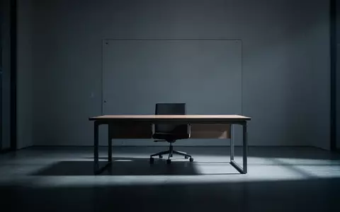 Ein minimalistisch eingerichtetes, leeres Büro mit kühler Beleuchtung und Schattenwurf, das eine Atmosphäre digitaler Unsicherheit vermittelt. - Foto: über boerse-global.de