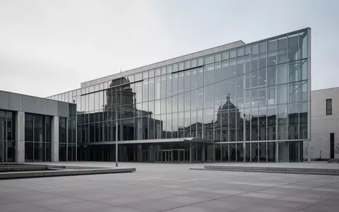 Ein modernes, minimalistisches Regierungsgebäude aus Glas und Stahl bei bewölktem Himmel. - Foto: über boerse-global.de