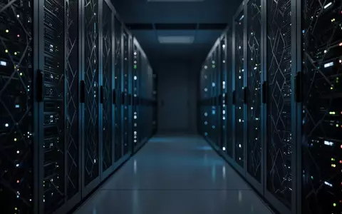 Dunkler Serverraum mit metallischen Schaltschränken und subtilen Status-LEDs in einer sterilen, technologischen Umgebung. - Foto: über boerse-global.de
