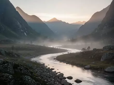 Eine friedliche Berglandschaft im Morgengrauen mit einem ruhig fließenden Fluss durch ein nebeliges Tal. - Foto: über boerse-global.de