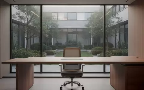 Ein aufgeräumter, minimalistischer Arbeitsplatz mit einem Holztisch und einem Fenster mit Blick in einen Innenhof. - Foto: über boerse-global.de