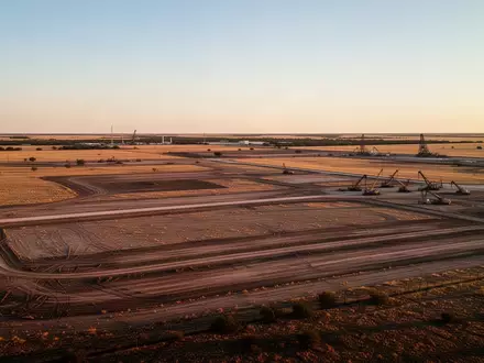 Weite, unbebaute Industriefläche in der texanischen Prärie bei Sonnenuntergang. - Foto: über boerse-global.de