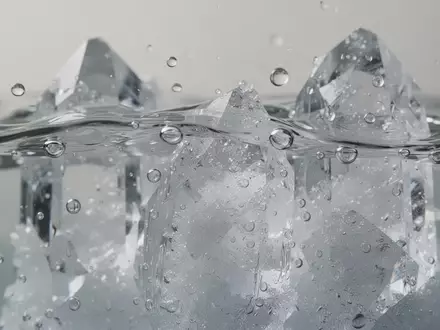 Nahaufnahme von kristallinen Strukturen und Wassertropfen, die chemische Lösungsprozesse auf molekularer Ebene symbolisieren. - Foto: über boerse-global.de