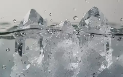 Nahaufnahme von kristallinen Strukturen und Wassertropfen, die chemische Lösungsprozesse auf molekularer Ebene symbolisieren. - Foto: über boerse-global.de